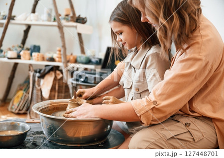 Teaching the art of pottery. Mother with little girl in the workshop 127448701
