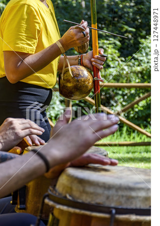 Group of people playing berimbau and atabaque Group of people playing berimbau and atabaque 127448971
