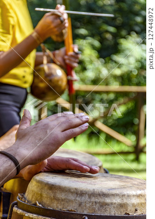 Hands of musicians playing berimbau and atabaque 127448972