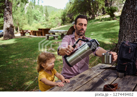 Father and Daughter Enjoying a Relaxing Moment Outdoors in a Scenic Park Area Father and Daughter Enjoying a Relaxing Moment Outdoors in a Scenic Park Area 127449402