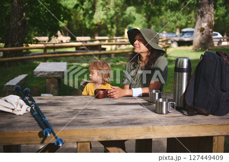 Mother and Child Enjoying Nature at a Picnic Table in a Forest Campground Mother and Child Enjoying Nature at a Picnic Table in a Forest Campground 127449409