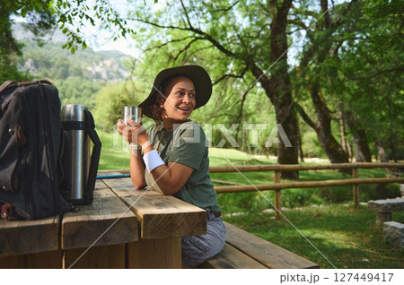 Woman Enjoying Outdoor Camp in Scenic Wooded Area Woman Enjoying Outdoor Camp in Scenic Wooded Area 127449417