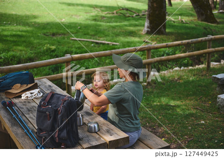 Mother and Child Enjoying a Lunch Break in a Serene Outdoor Setting Mother and Child Enjoying a Lunch Break in a Serene Outdoor Setting 127449425