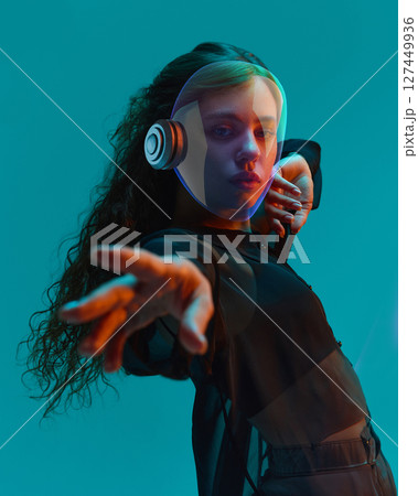 Futuristic 3D helmeted woman reaching out under teal light. Youth culture concept Futuristic 3D helmeted woman reaching out under teal light. Youth culture concept 127449936