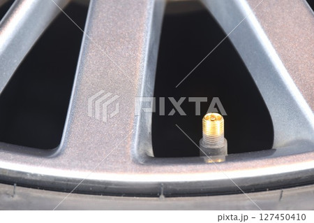 brass screw tire value on magnesium alloy wheel background and texture 127450410