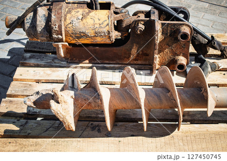 Heavy machinery parts on wooden pallets at a construction site during daylight hours Heavy machinery parts on wooden pallets at a construction site during daylight hours 127450745