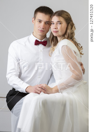 Classic vertical portrait of the bride and groom on a gray background. Classic vertical portrait of the bride and groom on a gray background. 127451520