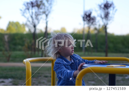 Cute Girl Enjoying Carousel Ride at Playground Cute Girl Enjoying Carousel Ride at Playground 127451589