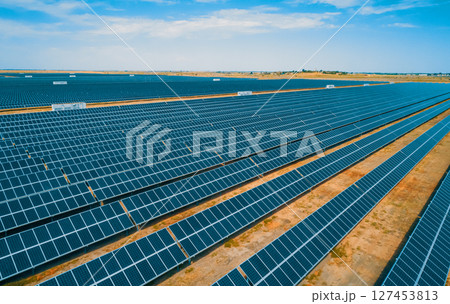 Expansive solar panel arrays under a clear blue sky in a vast renewable energy farm Expansive solar panel arrays under a clear blue sky in a vast renewable energy farm 127453813
