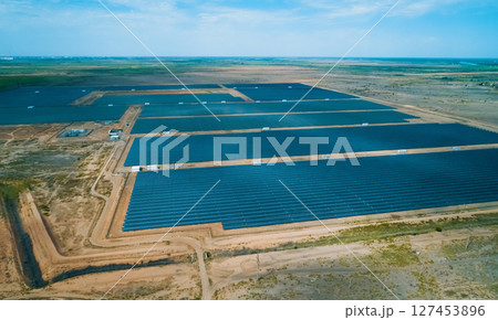 Solar energy farm located in a vast arid landscape generating renewable energy under clear blue skies Solar energy farm located in a vast arid landscape generating renewable energy under clear blue skies 127453896