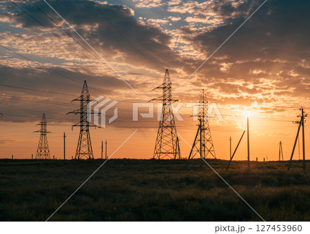 Sunset sky with power lines stretching over a desert landscape. Sunset sky with power lines stretching over a desert landscape. 127453960