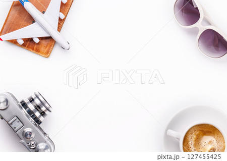 Travel-themed flat lay with toy airplane, camera, and coffee 127455425