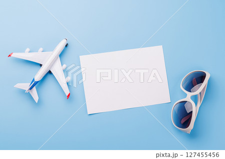 Travel-themed flat lay with blank photo card, sunglasses, toy airplane Travel-themed flat lay with blank photo card, sunglasses, toy airplane 127455456