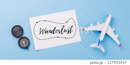Travel-themed flat lay with card, compass, toy airplane Travel-themed flat lay with card, compass, toy airplane 127455457