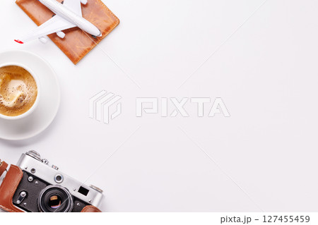 Travel-themed flat lay with toy airplane, camera, and coffee 127455459