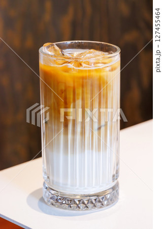 Iced latte in a clear glass with visible coffee and milk layers 127455464