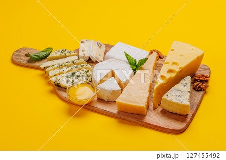 An assortment of various cheeses arranged on a board, highlighting different textures 127455492