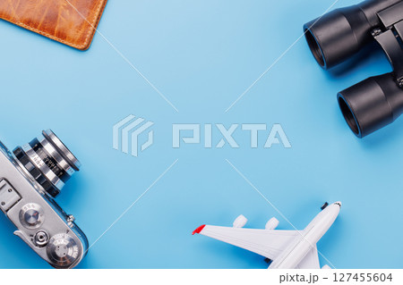 Travel-themed flat lay with toy airplane, camera, and passport Travel-themed flat lay with toy airplane, camera, and passport 127455604