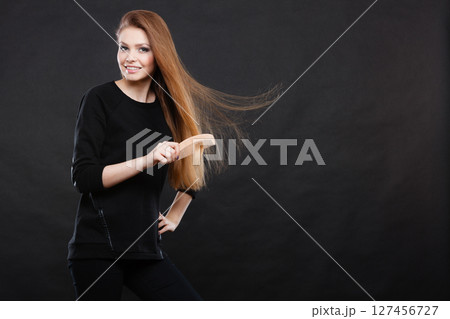 Long haired girl combing her beauty hair. 127456727