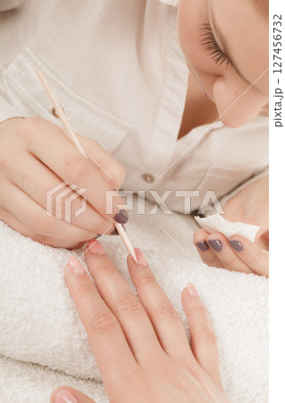 Beautician preparing nails before manicure, pushing back cuticles Beautician preparing nails before manicure, pushing back cuticles 127456732