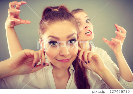 Fury girl screaming at her friend, female closing his ears Fury girl screaming at her friend, female closing his ears 127456759