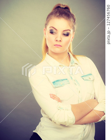 Angry woman looking very displeased standing with arms folded Angry woman looking very displeased standing with arms folded 127456760