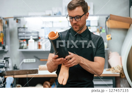 Holding prosthesis. Technician working in modern laboratory 127457135