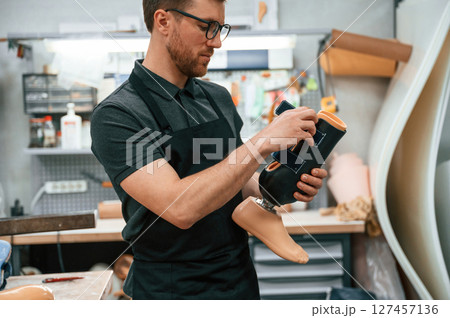 Holding prosthesis. Technician working in modern laboratory Holding prosthesis. Technician working in modern laboratory 127457136