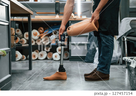 Prosthesis on the floor. Technician working in modern laboratory Prosthesis on the floor. Technician working in modern laboratory 127457154