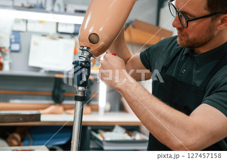 Twists the hexagon. Technician working with prosthesis in modern laboratory Twists the hexagon. Technician working with prosthesis in modern laboratory 127457158
