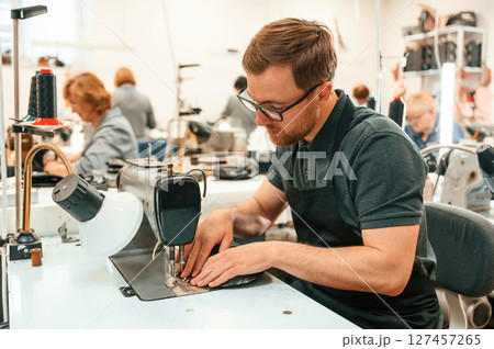 Working by sewing machine. Technician is indoors Working by sewing machine. Technician is indoors 127457265