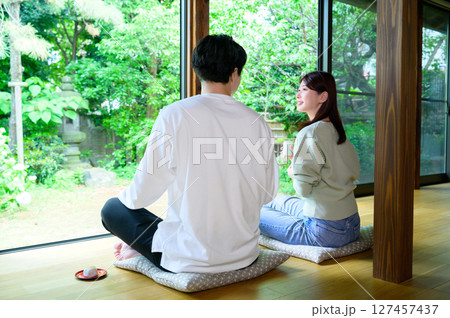 窓際に座っている男女が正座しながら外の景色を眺めて穏やかな時間を共有する 127457437