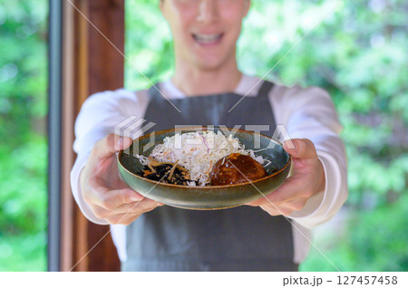 男性が両手でカメラ前方にハンバーグを差し出す構図で料理の魅力が引き立つ接写シーン 男性が両手でカメラ前方にハンバーグを差し出す構図で料理の魅力が引き立つ接写シーン 127457458