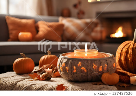 cozy living room, where the soft glow of burning candles illuminates the intricate knitting patterns on the throw pillows and blankets. 127457526