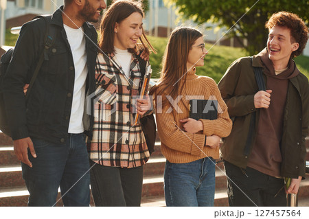 Front view. Four young students in casual clothes are together outdoors 127457564