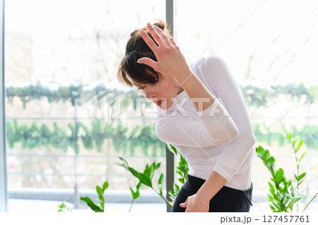 Woman in fluid contemporary dance pose near bright window. Woman in fluid contemporary dance pose near bright window. 127457761