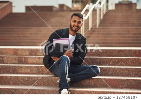 Handsome Indian student is outdoors Handsome Indian student is outdoors 127458107