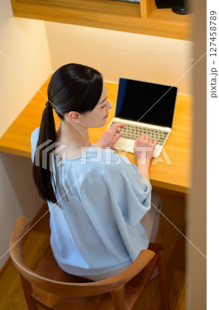 パソコンを操作する日本人女性の後ろ姿 127458789
