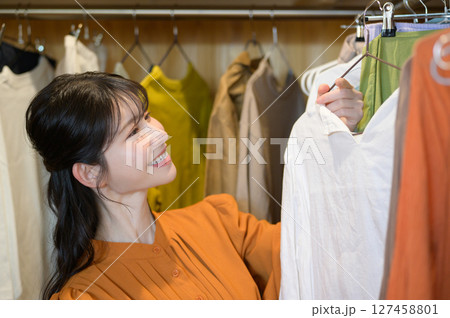ウォークインクローゼットで服を選ぶ日本人女性 127458801