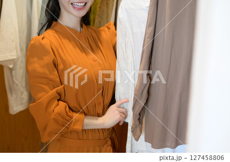 ウォークインクローゼットで服を選ぶ日本人女性 127458806