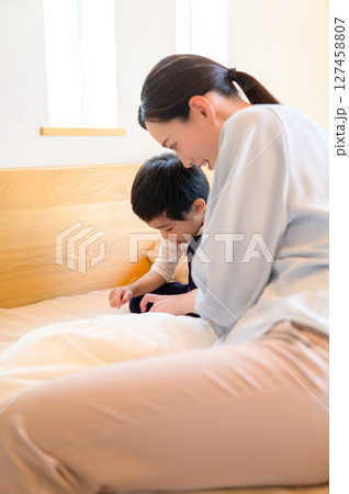 ベッドの上で子供と遊ぶ日本人女性 127458807
