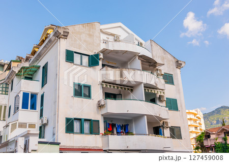 Old residential building with open balconies and laundry drying. Urban housing, daily life, and Mediterranean lifestyle in coastal city. 127459008