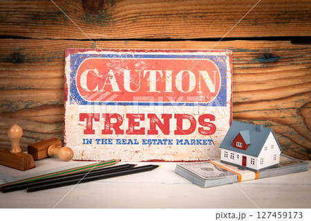 Trends in the real estate market. Caution Sign in with House Model and Money Stack on Desk Trends in the real estate market. Caution Sign in with House Model and Money Stack on Desk 127459173