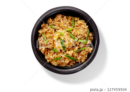 Delicious fried rice with chicken and sesame seeds in a black bowl Delicious fried rice with chicken and sesame seeds in a black bowl 127459504