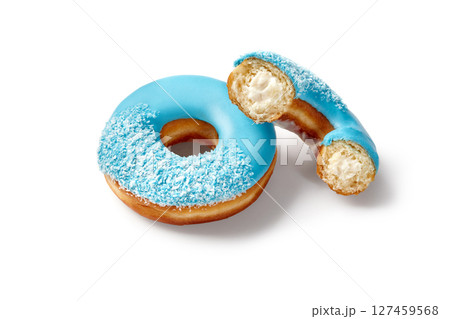 Two tasty blue donuts with coconut flakes and cream filling resting on white background 127459568