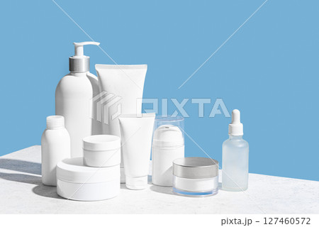 Blank cosmetic containers on light blue background 127460572