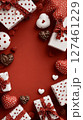 Festive Red Background With White and Brown Gifts and Heart-Shaped Chocolates Arranged for Celebration 127461229
