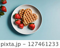 Heart-shaped Waffles With Fresh Strawberries on a Blue Background for a Delightful Breakfast 127461233