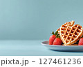 Heart-shaped Waffles With Fresh Strawberries on a Light Blue Plate 127461236