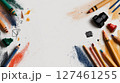 Creative Workspace Featuring Colorful Art Supplies and Drawing Tools on White Canvas. 127461255